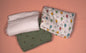 Three folded Blankets with different patterns on a pink background