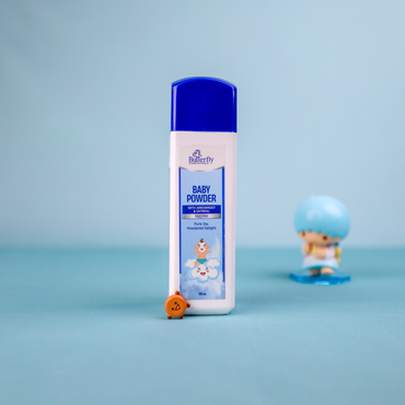 Butterfly baby powder bottle on a blue background with a small figurine.